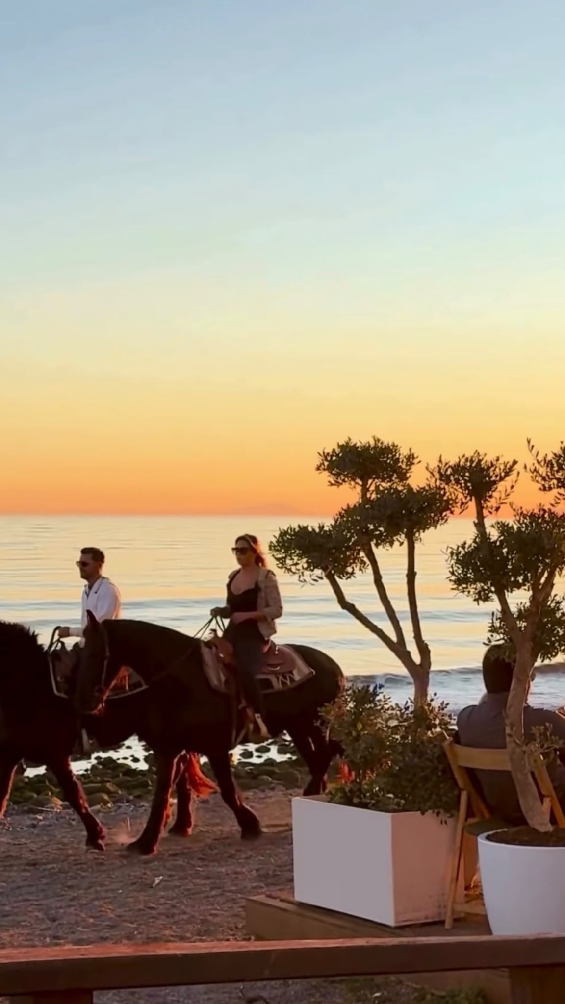 Two riders passing a Mediterranean sunset viewpoint